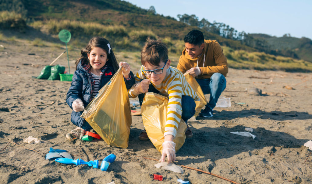 Eine Gruppe junger Freiwilliger sammelt Müll am Strand auf