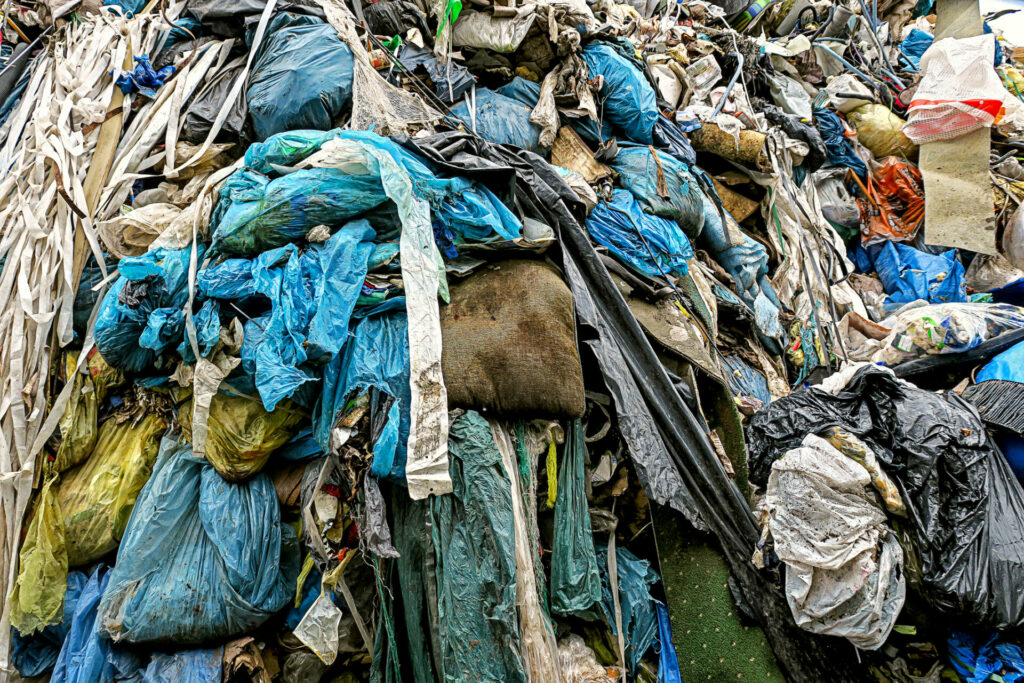 Ein großer Haufen aus bunten Plastiksäcken, Folien und Unrat, zum Thema Sustainable Fashion vs. Fast Fashion.